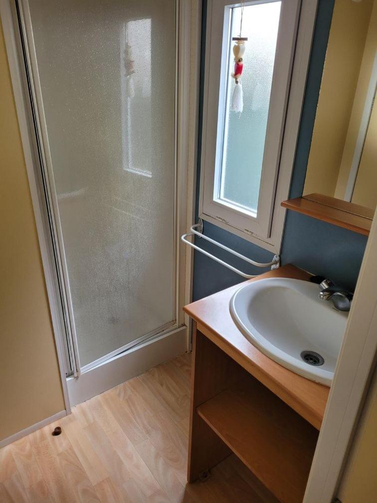 une salle de bain avec un lavabo et une douche dans l'établissement Location Mobil home Camping Pédro, au Grau-dʼAgde