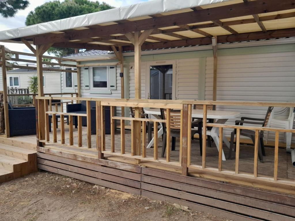 une terrasse avec une pergola et une table dans l'établissement Location Mobil home Camping Pédro, au Grau-dʼAgde