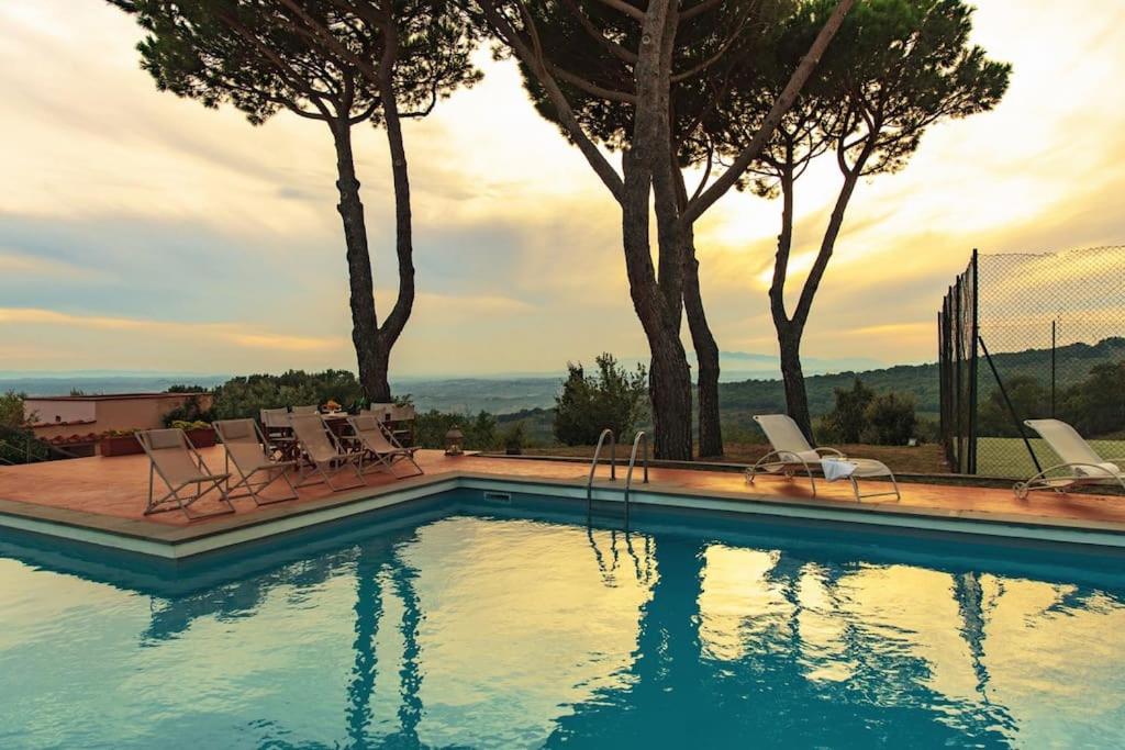 une piscine avec des chaises et des arbres en arrière-plan dans l'établissement Villa Belvedere Il Melograno, à San Giusto
