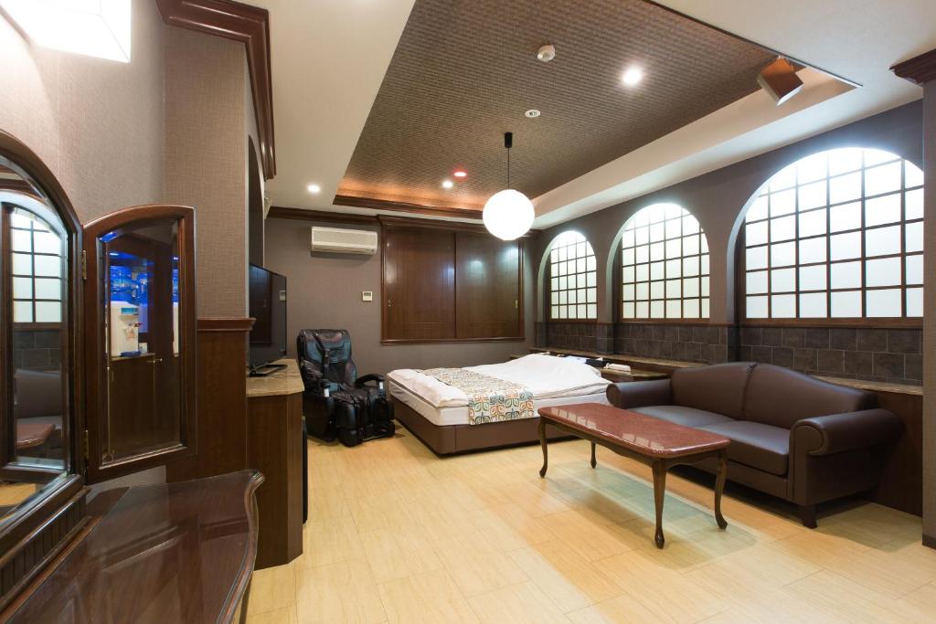 une chambre d'hôpital avec un lit et un canapé dans l'établissement ホテルシエル沼津店 沼津インター -大人専用-, à Numazu