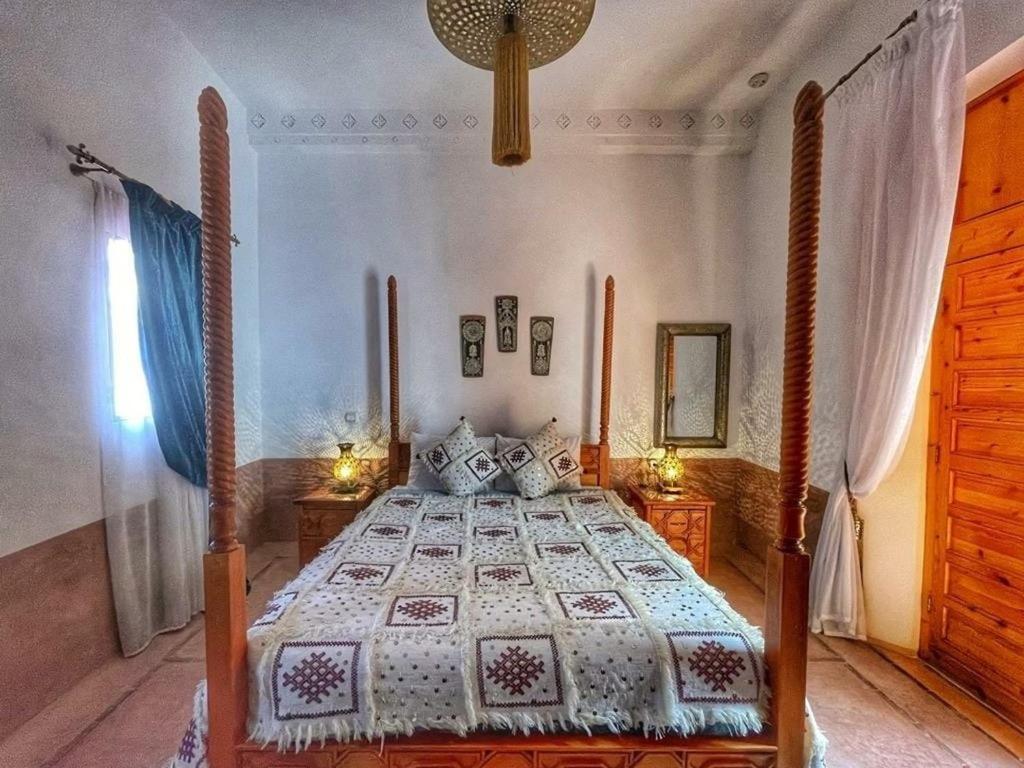 - une chambre avec un lit doté d'un cadre de lit en bois dans l'établissement Dar 14 Marrakech, à Marrakech