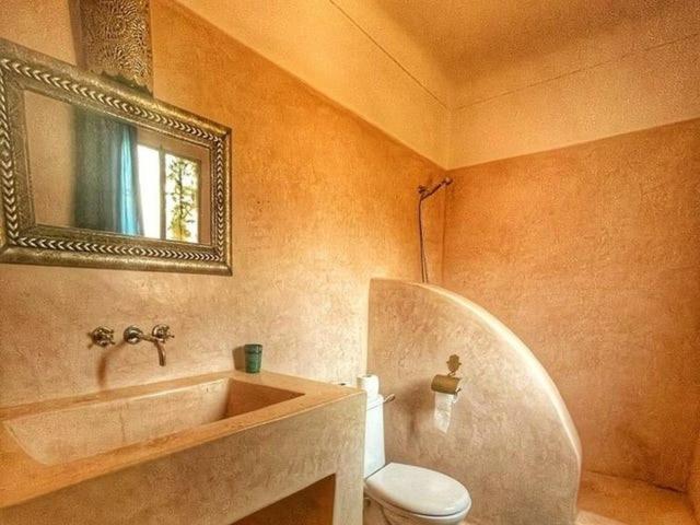 une salle de bain avec un lavabo, des toilettes et un miroir dans l'établissement Dar 14 Marrakech, à Marrakech