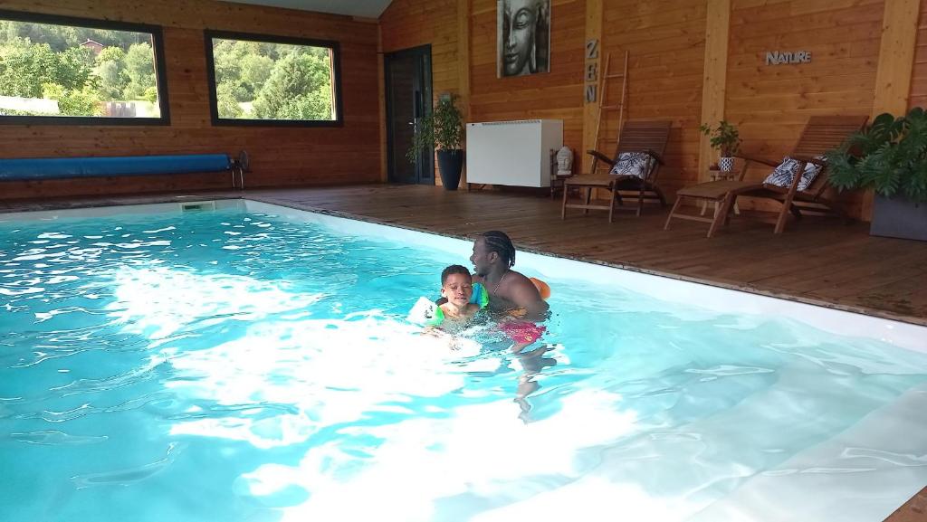 un homme et un enfant dans une piscine dans l'établissement Les Chalets du Lac Belcaire, à Belcaire
