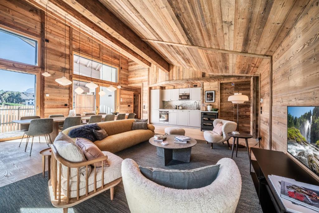 un salon avec un canapé et des chaises dans l'établissement Apartment Tourmalet Carrôz d'Arâches - BY EMERALD STAY, aux Carroz d'Arâches