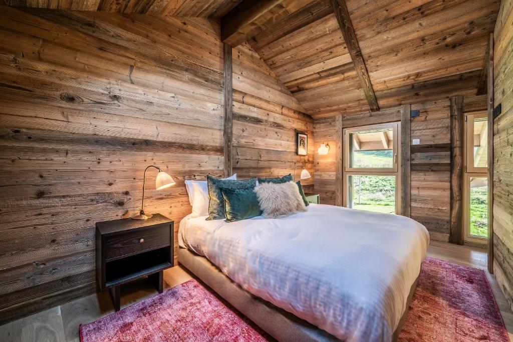 une chambre avec un lit et un mur en bois dans l'établissement Apartment Tourmalet Carrôz d'Arâches - BY EMERALD STAY, aux Carroz d'Arâches