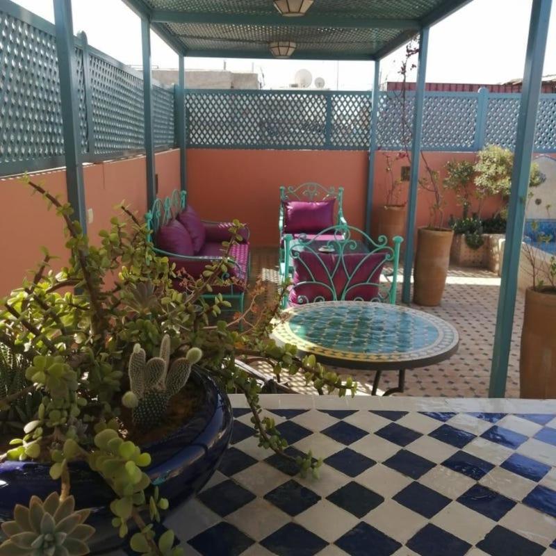 un patio avec des chaises et une table avec des plantes dans l'établissement Dar 14 Marrakech, à Marrakech