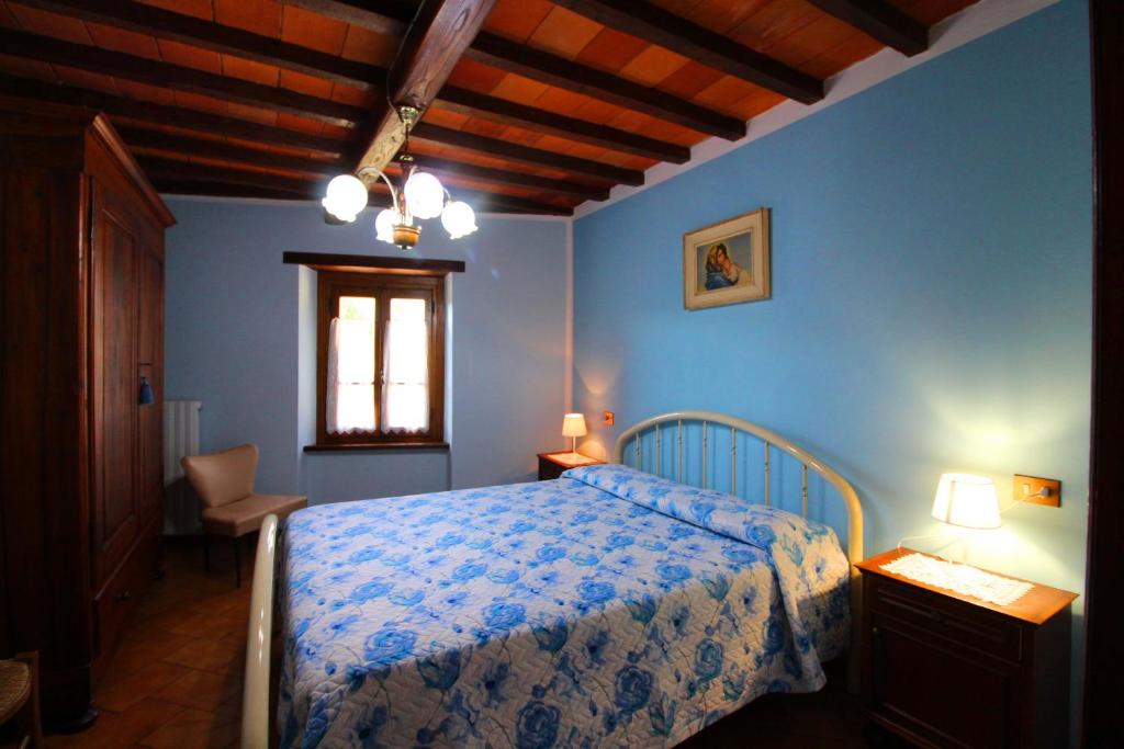 une chambre avec un lit aux murs bleus et une fenêtre dans l'établissement VILLA CASALTE, à Castel Focognano