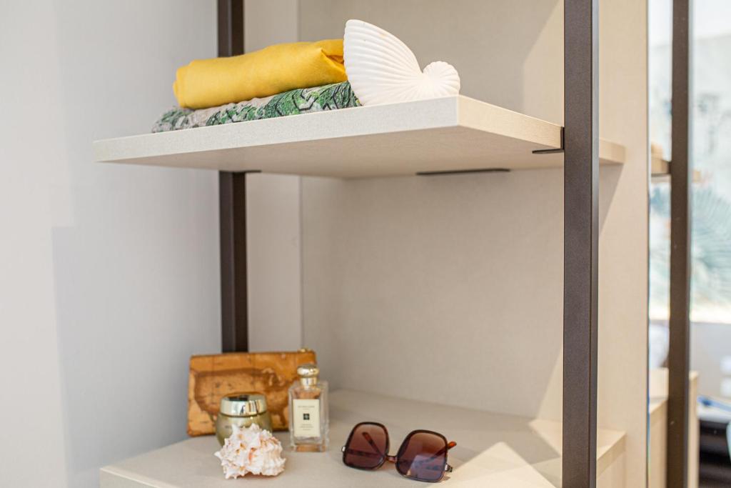 - une étagère dans un placard avec des chaussures et des serviettes dans l'établissement Hotel Excelsior, à Bibione