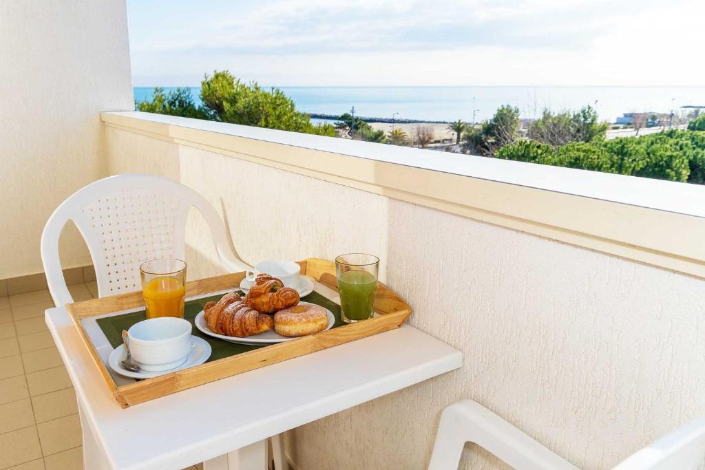 - un plateau de petit-déjeuner sur un balcon dans l'établissement Hotel Club La Villa, à Martinsicuro
