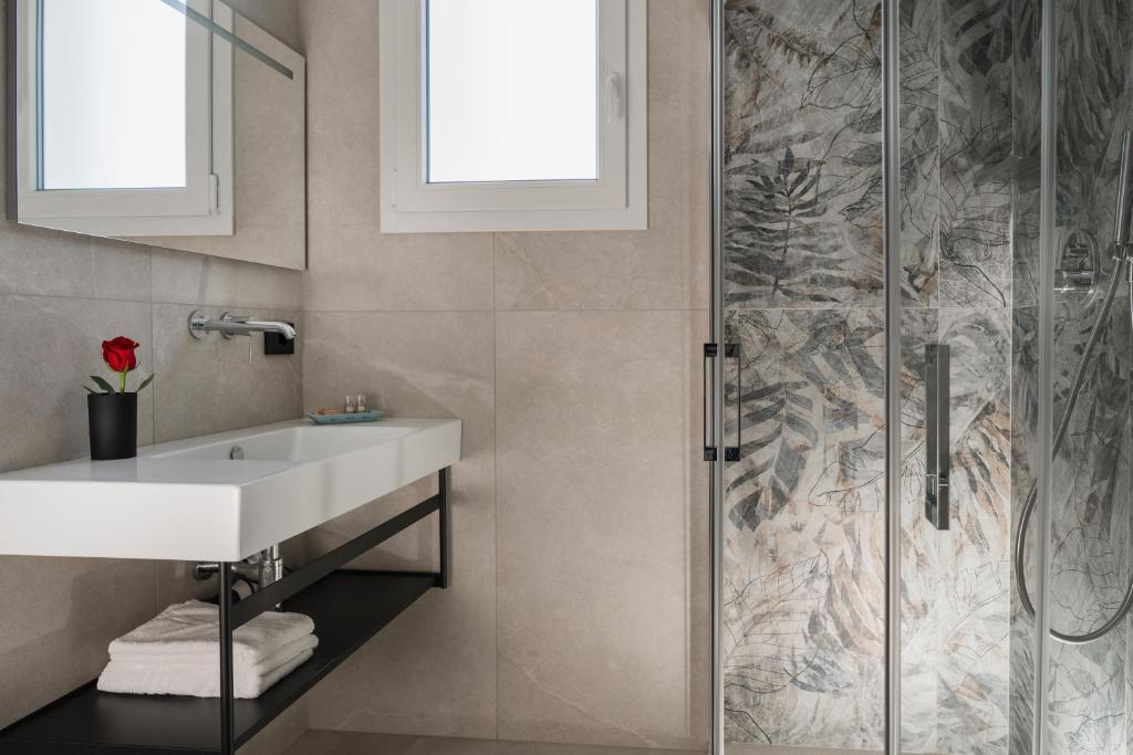 une salle de bain avec un lavabo et une douche dans l'établissement Hotel Ascot Riccione, à Riccione