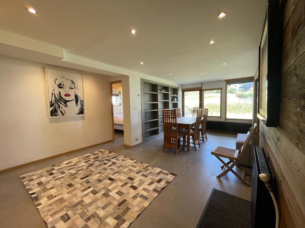 - un salon avec une table et une photo de chien sur le mur dans l'établissement Ski in-Ski out! Spacious & Stylish Apartment for 8 in the heart of Lavachet, à Tignes