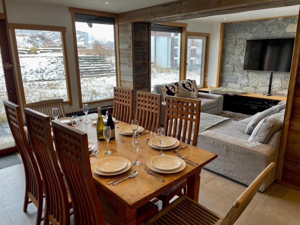 une salle à manger avec une table et un canapé dans l'établissement Ski in-Ski out! Spacious & Stylish Apartment for 8 in the heart of Lavachet, à Tignes