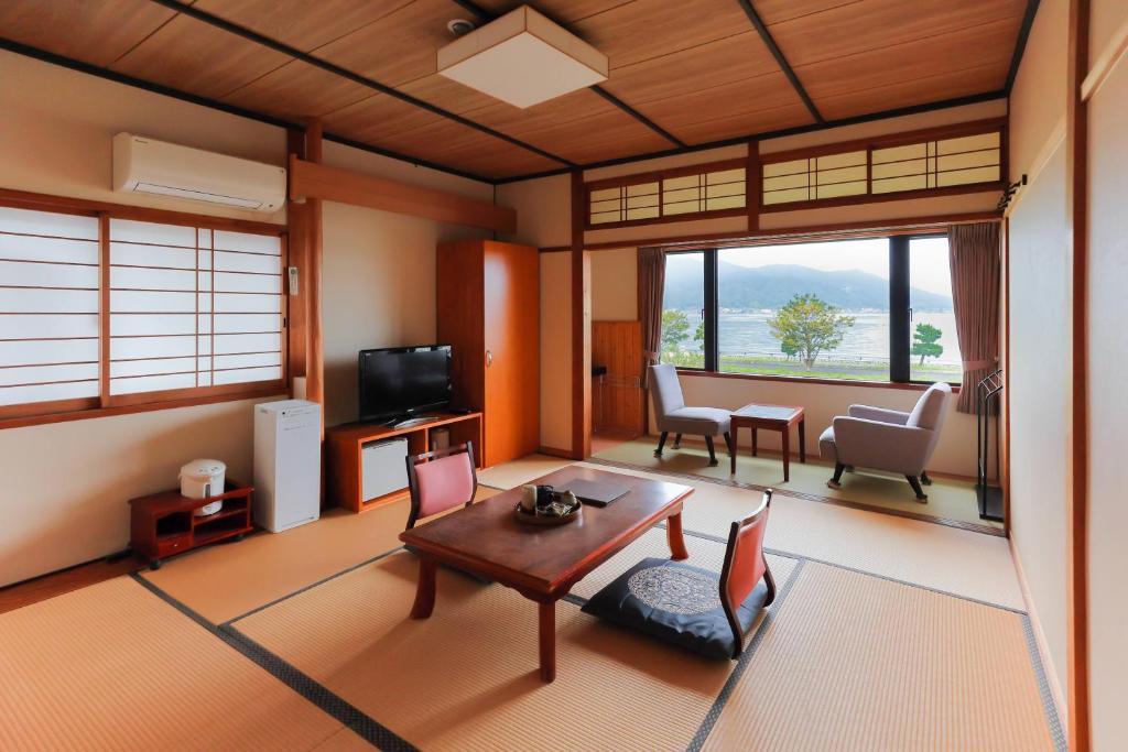 un salon avec une table et des chaises dans l'établissement Jinpuso, à Miyazu