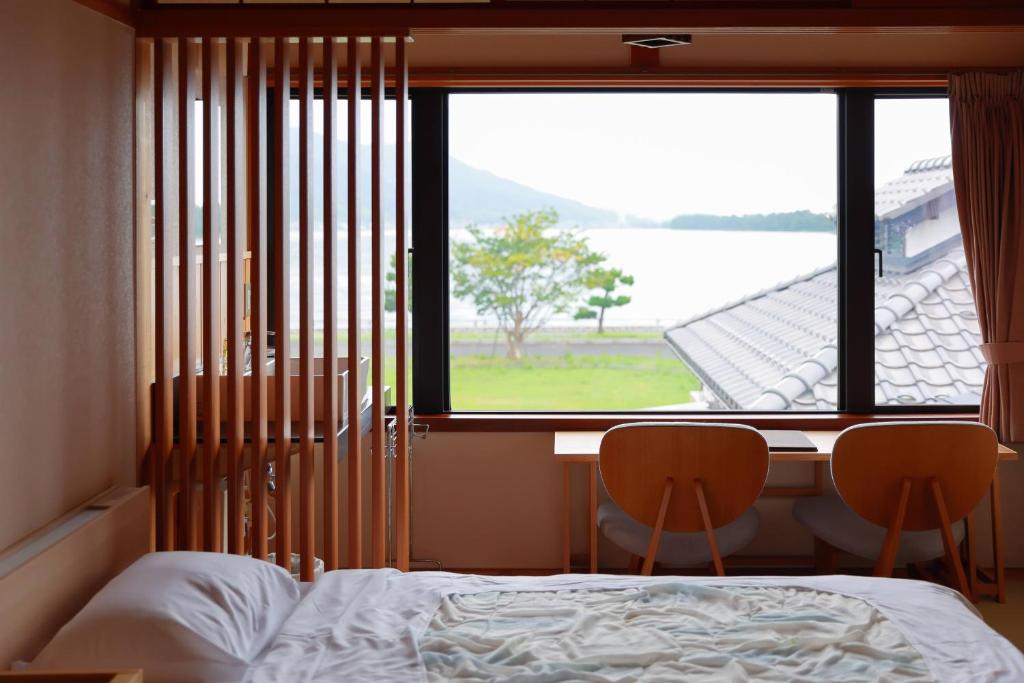 une chambre avec un lit, un bureau et une fenêtre dans l'établissement Jinpuso, à Miyazu 37 autres photos