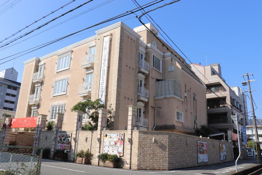 un grand bâtiment en briques sur le côté d'une rue dans l'établissement ホテルシエル, à Himeji