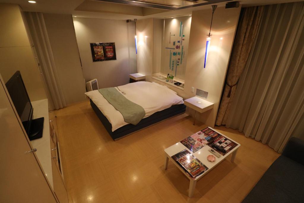 une petite pièce avec un lit et une table dans l'établissement ホテルシエル, à Himeji