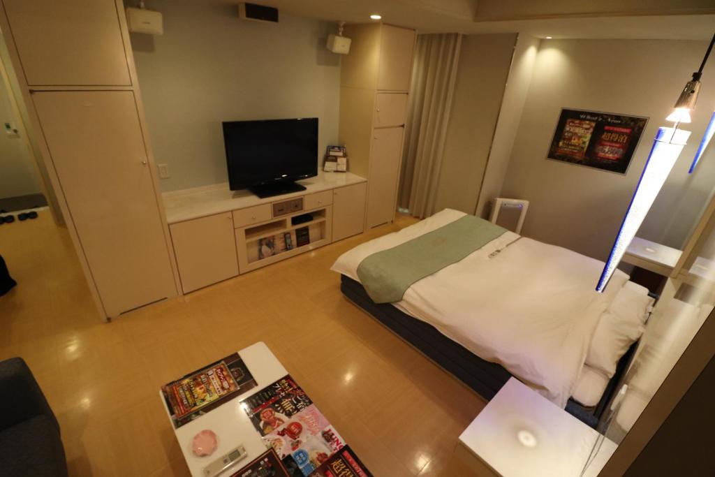 une petite chambre avec un lit et une télévision à écran plat dans l'établissement ホテルシエル, à Himeji 1 autre photo