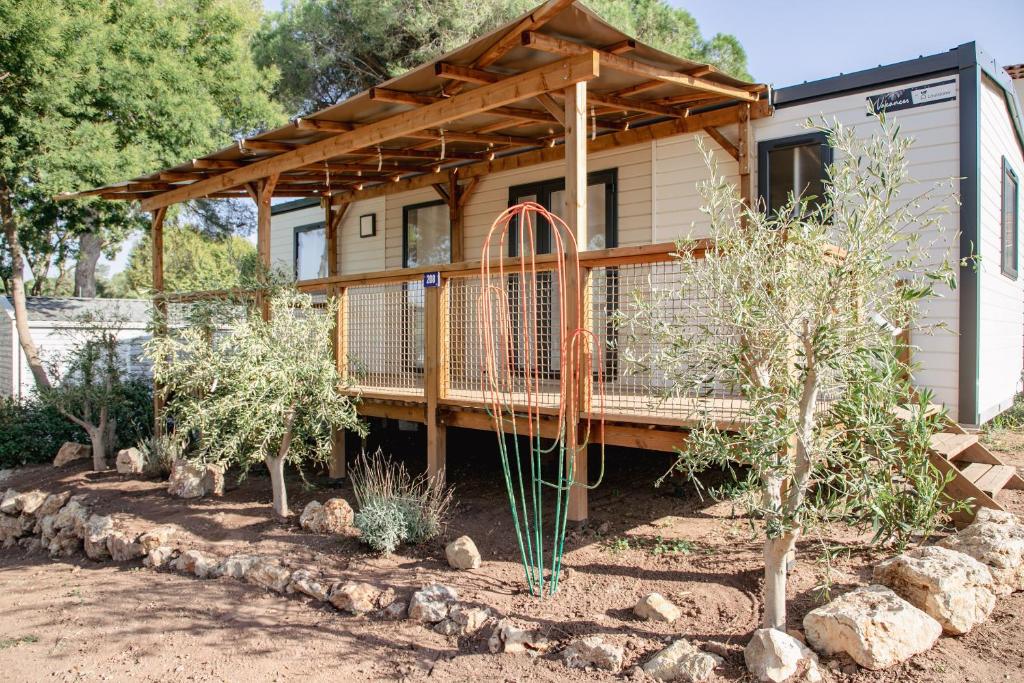une petite maison avec une terrasse dans une cour dans l'établissement Camping Site de Gorge Vent, à Fréjus