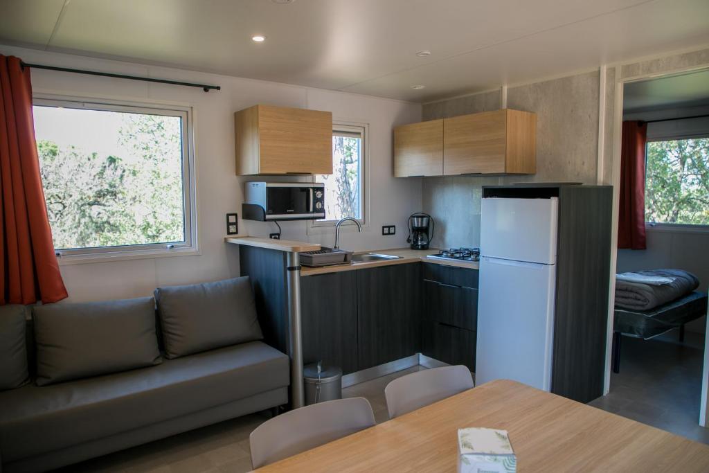 Il dispose d'une cuisine et d'un salon avec un canapé et un réfrigérateur. dans l'établissement Camping Site de Gorge Vent, à Fréjus