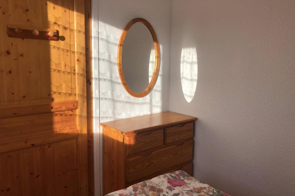 - une chambre avec un miroir et une commode en bois dans l'établissement Nice 37m near the center of La Salle-les-Alpes, à La Salle Les Alpes