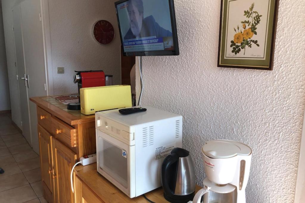 - un four micro-ondes installé au-dessus d'un comptoir de cuisine avec une télévision dans l'établissement Nice 37m near the center of La Salle-les-Alpes, à La Salle Les Alpes 3 autres photos