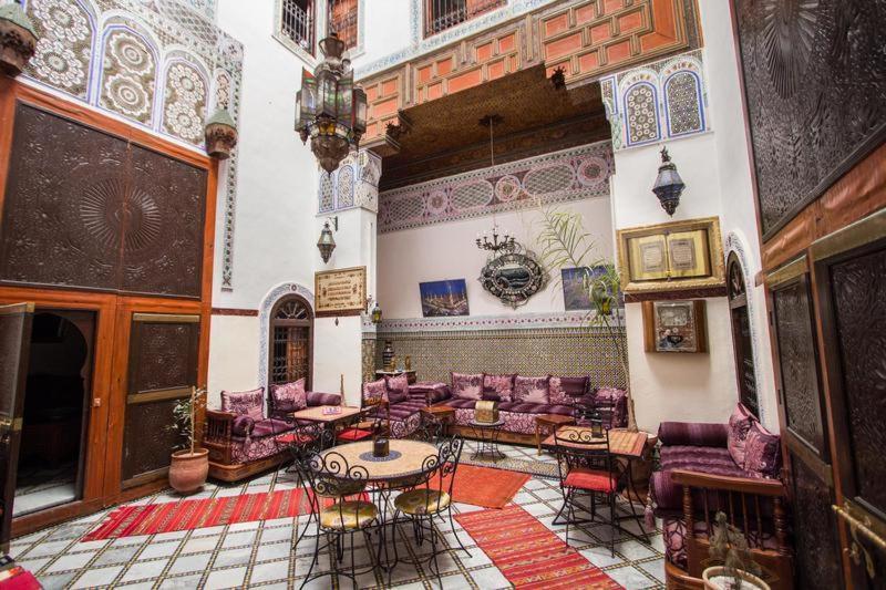 - un salon avec des chaises et des tables violets dans un bâtiment dans l'établissement Riad Meski, à Fès