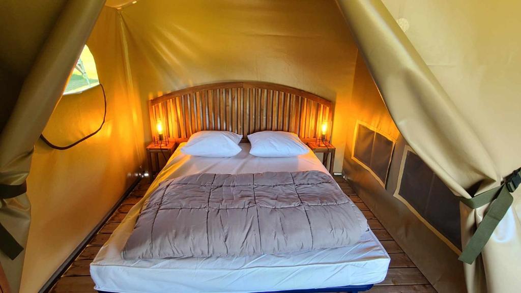 une chambre avec un lit dans une tente dans l'établissement Le Domaine du Bois Coquet, à La Douze 37 autres photos