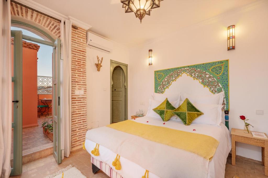 une chambre avec un lit et un balcon dans l'établissement Riad Dar Azal, à Marrakech