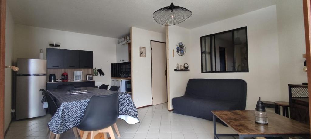 Il comprend une cuisine et un salon avec une table et une chaise. dans l'établissement Appart 4-6 pers au pied des pistes toutes saisons, à Molines-en-Queyras