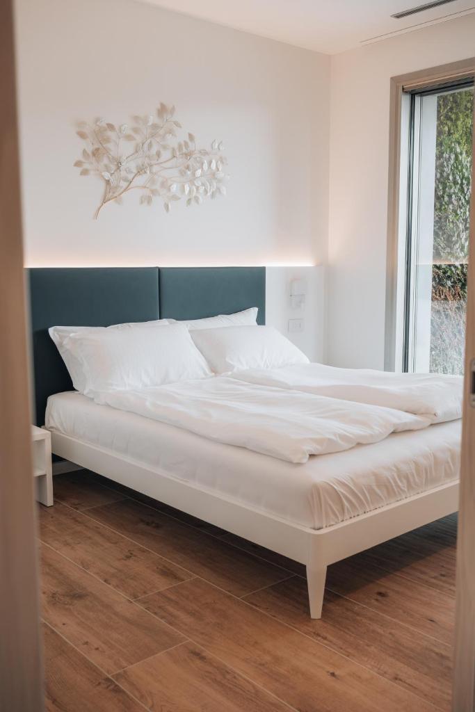 un lit blanc dans une chambre avec une fenêtre dans l'établissement Sea Breeze, à Caorle