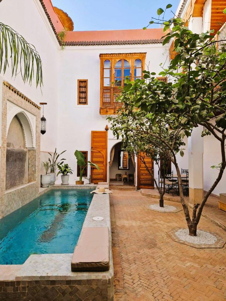 une cour avec une piscine dans une maison dans l'établissement RIAD SAMAH, à Marrakech