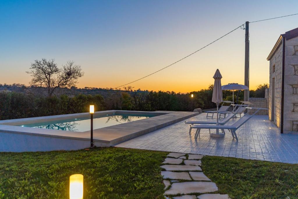 une cour avec une piscine, un banc et une table dans l'établissement House Nicasia: villa con piscina, à Raguse