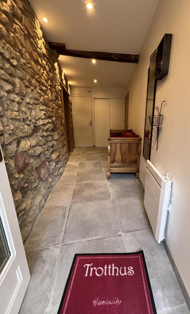 un couloir avec un mur de pierre et un tapis rouge dans l'établissement Gite familiale avec piscine Hunawihr - Ribeauvillé, à Hunawihr
