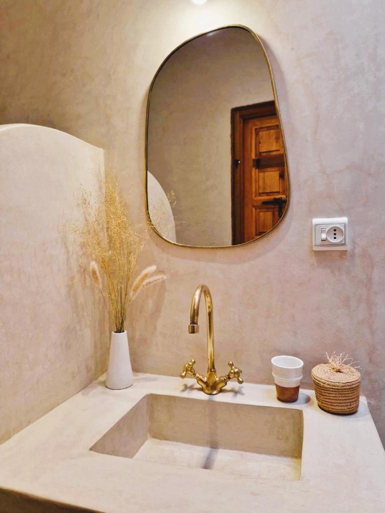 une salle de bain avec un lavabo et un miroir dans l'établissement RIAD SAMAH, à Marrakech