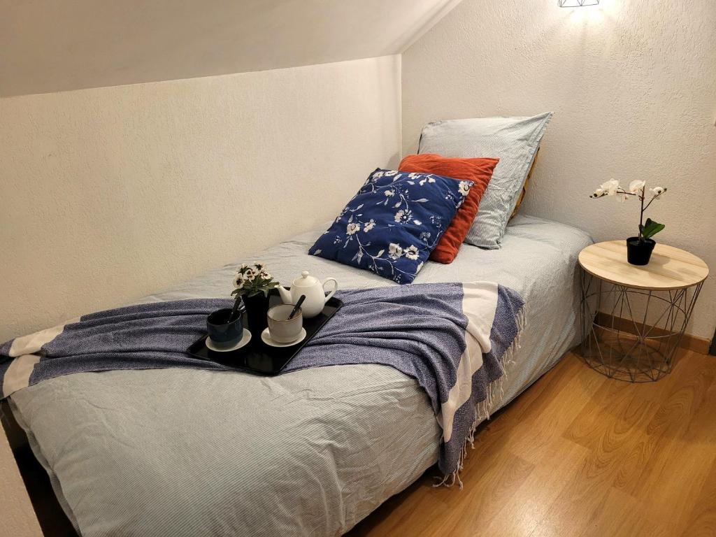 une chambre avec un lit avec deux oreillers dans l'établissement L'Esquiros, studio, centre Luchon, casier à skis, wifi, ascenseur, 3 personnes, à Luchon
