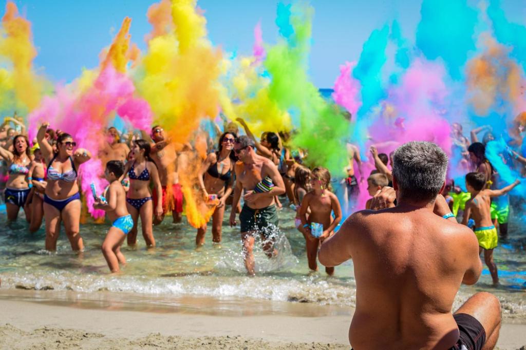 un groupe de personnes jouant dans l'eau à la plage dans l'établissement Hotel Thàlas Club, à Torre dell'Orso