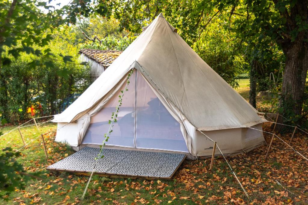 une tente assise sur l'herbe dans un parc dans l'établissement Dordogne Glamping, à Bouzic