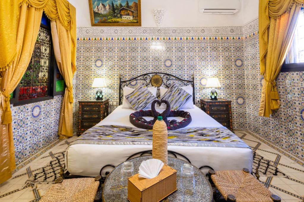 - une chambre avec un lit king-size et une table dans l'établissement Riad La Porte d'Or & SPA, à Marrakech