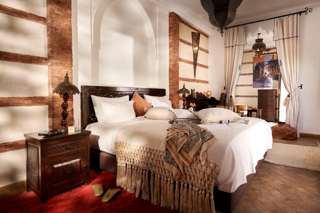 une chambre avec un grand lit avec des draps blancs dans l'établissement Riad Dar Amanza en exclusivité avec 4 chambres au coeur de la médina, à Marrakech