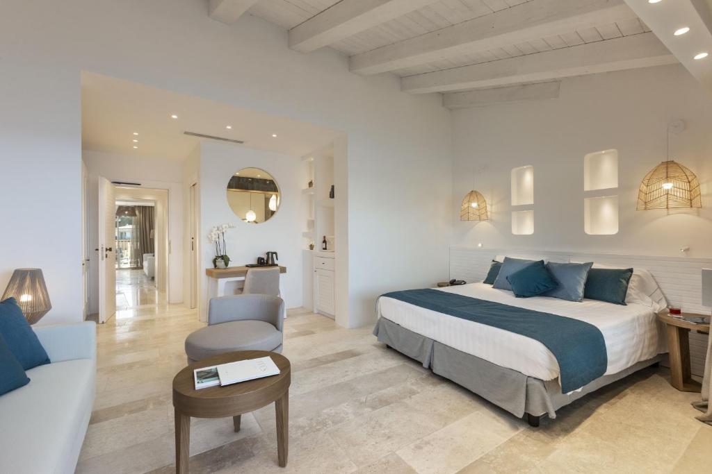 une chambre avec un lit et un salon dans l'établissement Club Hotel Baja Sardinia, à Baja Sardinia