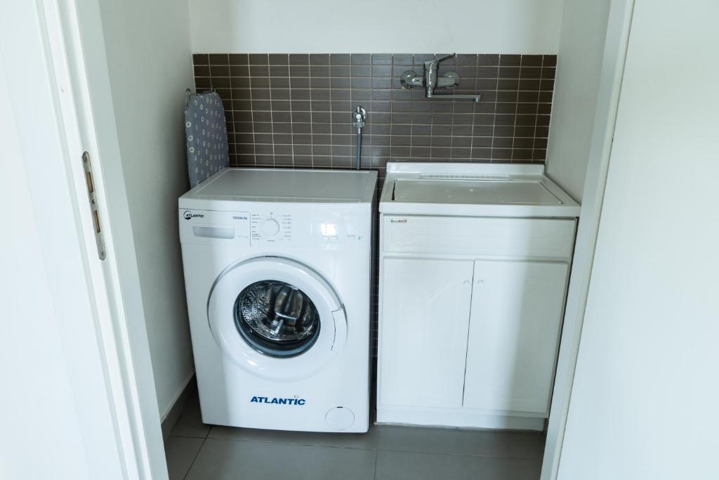 - un lave-linge et un sèche-linge dans une petite salle de bains dans l'établissement Ville Edilia Vacanze, à Marina di Ragusa