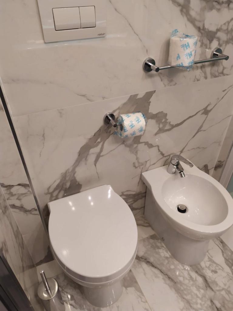 une salle de bain avec des toilettes blanches et un lavabo dans l'établissement Hotel Atlantic, à Rimini