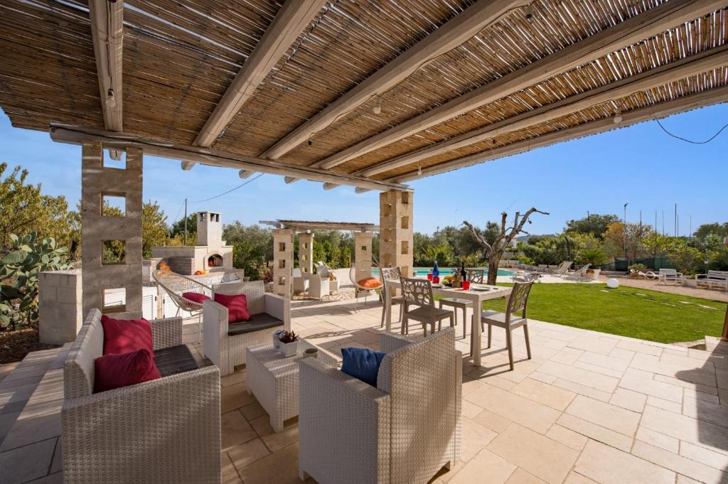 un patio extérieur avec une pergola en bois dans l'établissement Villa Trullo Saraceno by Villa Plus, à Ostuni