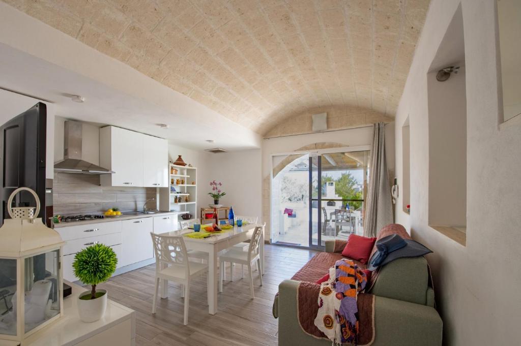 une cuisine et un salon avec un canapé et une table dans l'établissement Villa Trullo Saraceno by Villa Plus, à Ostuni