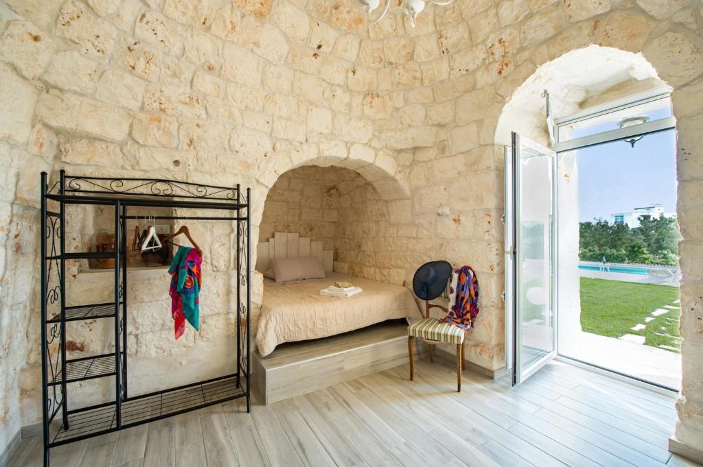 une chambre avec un lit dans un mur de pierre dans l'établissement Villa Trullo Saraceno by Villa Plus, à Ostuni