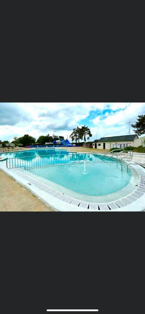 une grande piscine avec de l'eau bleue dans l'établissement Mobil Home tout confort idéal pour 4 personnes dans le Domaine de Dugny CAMPING 4 ETOILES, Proche de Blois, du Zoo de beauval et des Châteaux de la Loire, à Onzain