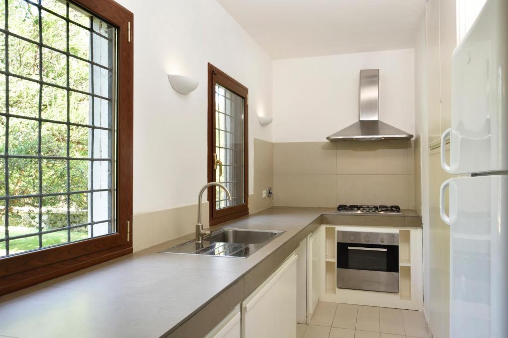 une cuisine blanche avec un évier et une fenêtre dans l'établissement Torre delle Cornacchie - Private Pool Villa, à Rome