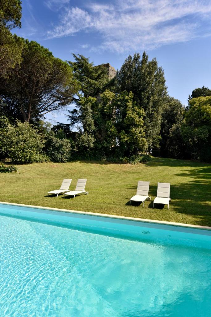 2 chaises longues blanches et une piscine dans l'établissement Torre delle Cornacchie - Private Pool Villa, à Rome