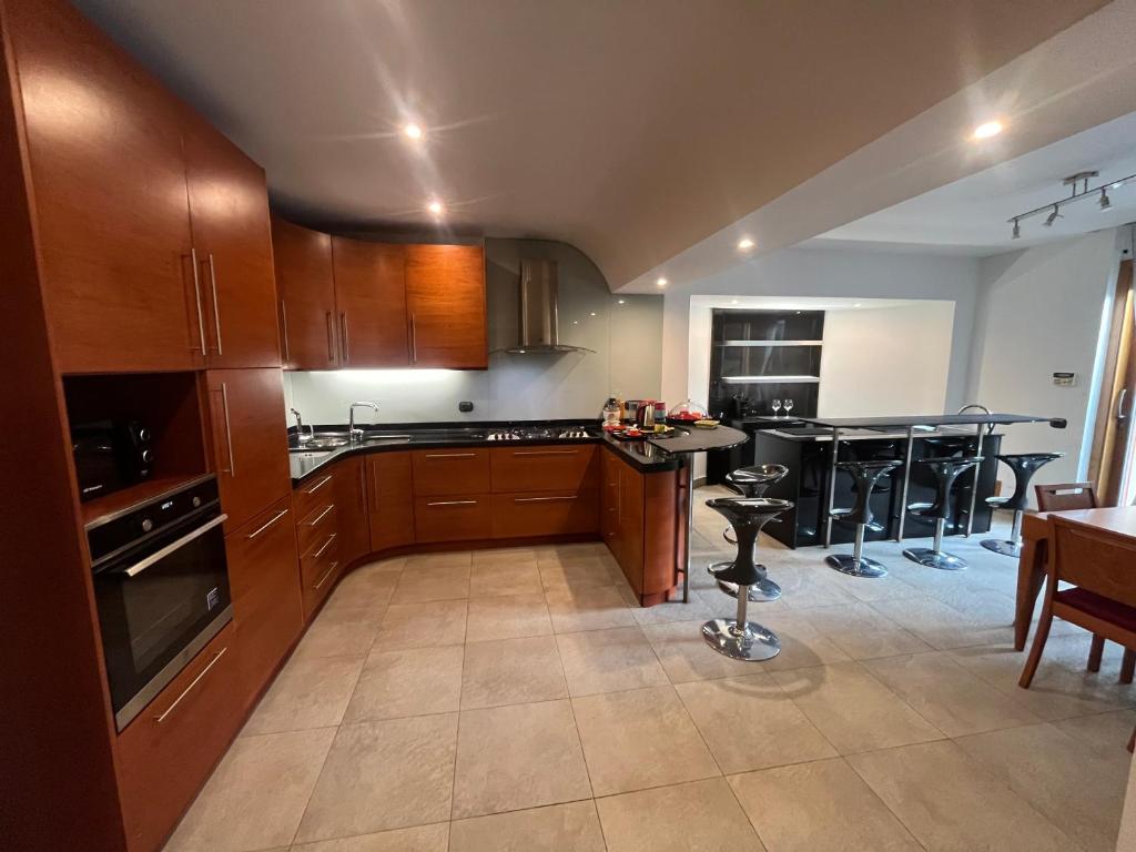 une cuisine avec des armoires en bois et une table et des chaises dans l'établissement Villa Roma Open Space - Location per eventi 2 piscine riscaldate -, à Rome