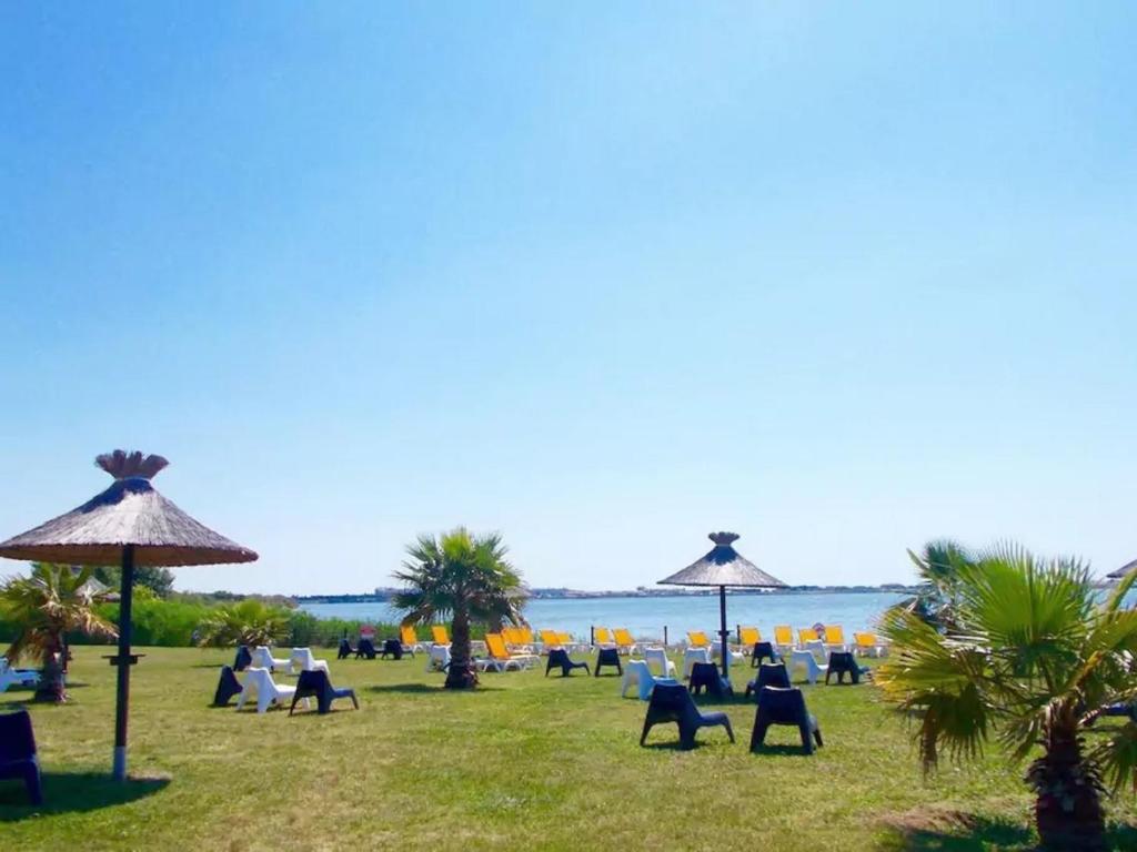 - un groupe de chaises longues et de parasols sur la plage dans l'établissement JP - L'Eleganzia 2 ch, clim réversible, Confort et Elégance,, à Lattes